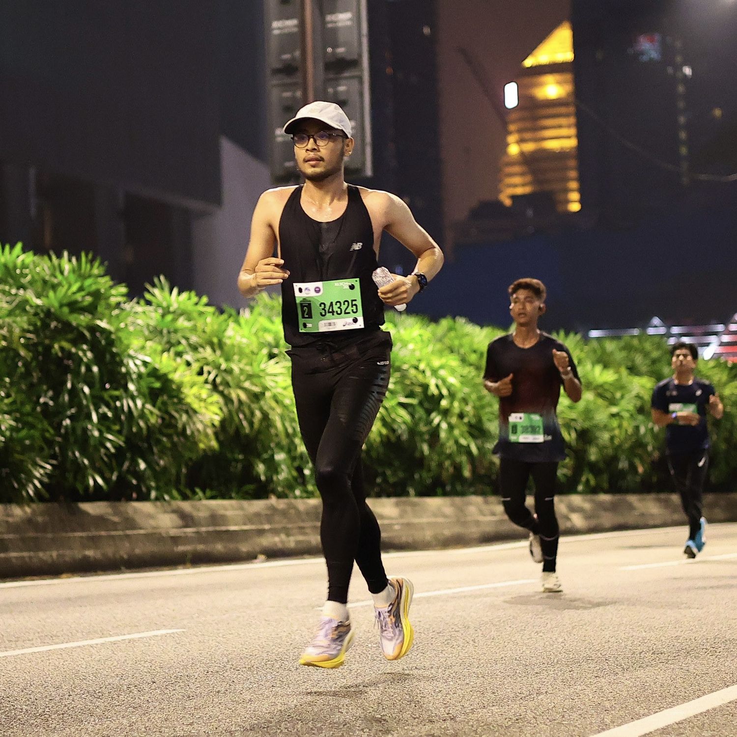 Haziq running through Kuala Lumpur at night during the KL Standard Chartered Half Marathon